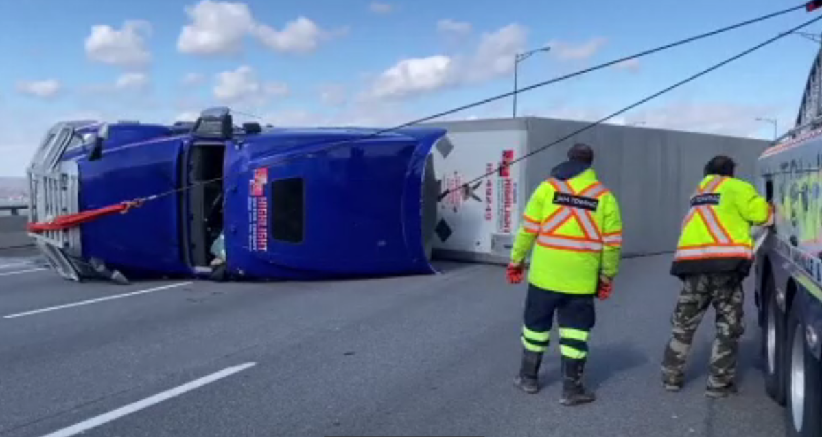 A transport truck has rolled over on the Burlington Skyway bridge, blocking lanes of the Niagara-bound QEW on Sunday. 