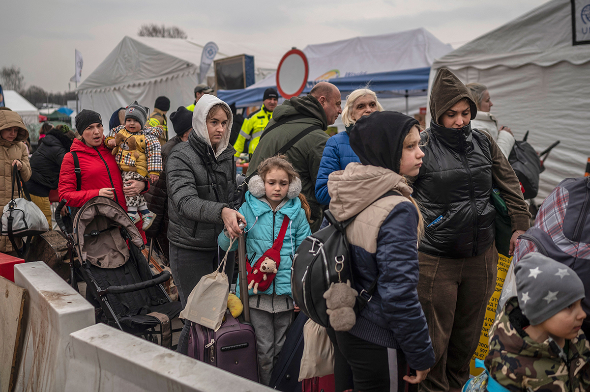 Ukrainian evacuees queue as they wait for further transport at the Medyka border crossing, after they crossed the Ukrainian-Polish border, southeastern Poland, on March 29, 2022.