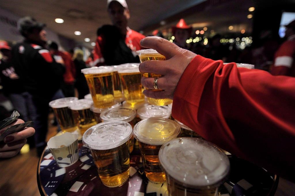 Hockey fans load up on beer at a bar in Edmonton on Dec. 31, 2011. The southern Alberta town of Raymond -- dry since it was founded more than 100 years ago -- is asking residents if they are for or against restaurants serving alcohol. THE CANADIAN PRESS/Nathan Denette.