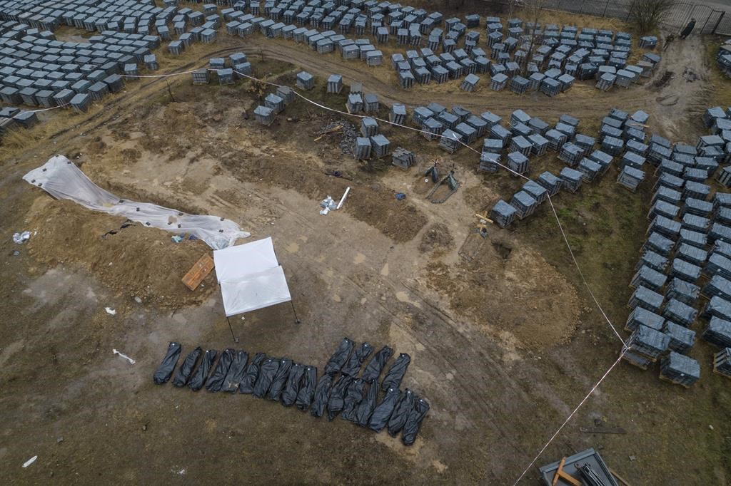 Plastic bags with corpses exhumed from a mass grave are lined up in Bucha, on the outskirts of Kyiv, Ukraine, Friday, April 8, 2022.
