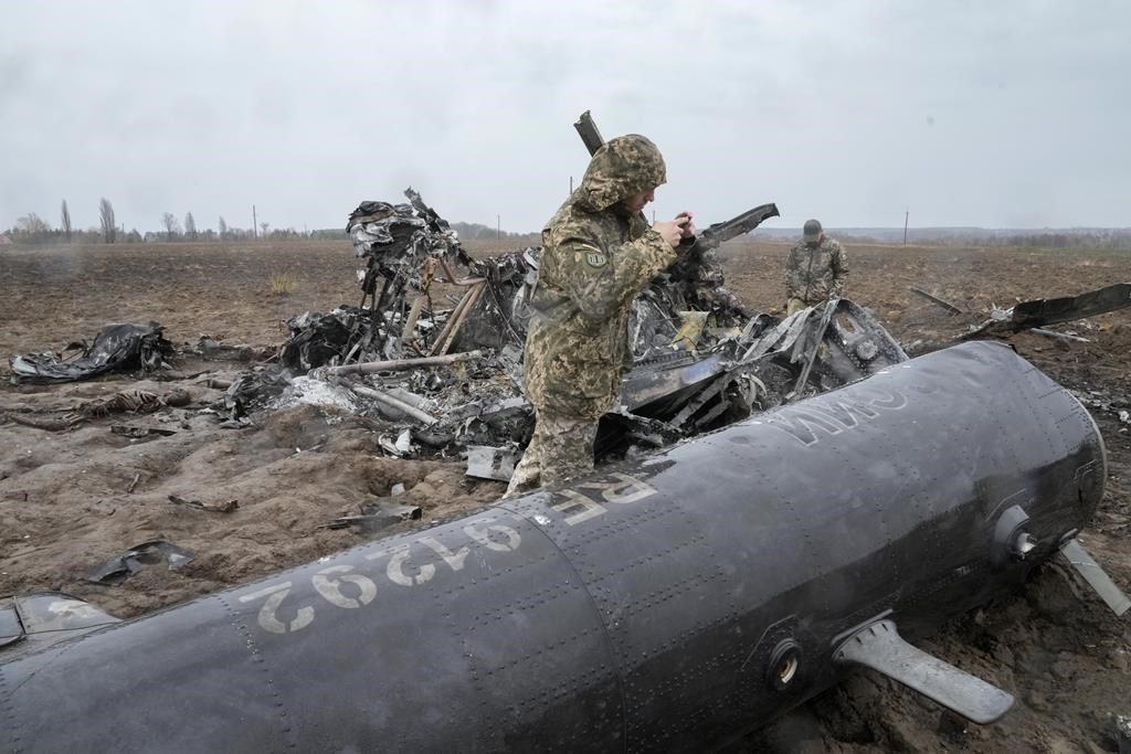 A Ukrainian soldier examines fragments of a Russian military helicopter near Makariv, near Kyiv, Ukraine. (AP Photo/Efrem Lukatsky)