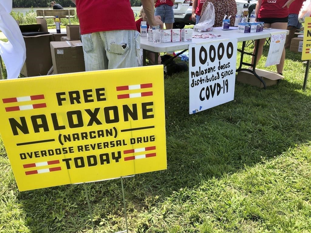 FILE – Signs are displayed at a tent during a health event on June 26, 2021, in Charleston, W.Va. The effort to hold drug companies, pharmacies and distributors accountable for their role in the opioid crisis has led to a whirlwind of legal activity around the United States. New legal settlements are being reached practically every week to provide governments money to fight the crisis, and in some cases funds for medicines to reverse overdoses or to help with treatment. (AP Photo/John Raby, File)
