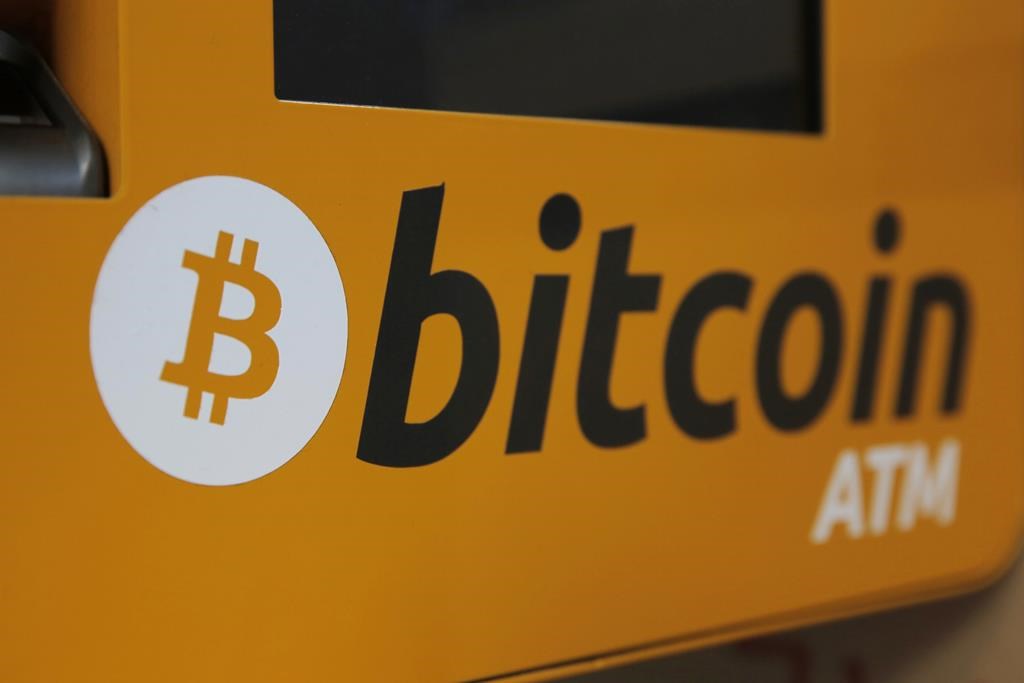 FILE - A Bitcoin logo is displayed on an ATM in Hong Kong, Thursday, Dec. 21, 2017. A cryptocurrency expert was sentenced Tuesday, April 12, 2022, to more than five years in federal prison for helping North Korea evade U.S. sanctions. (AP Photo/Kin Cheung, File).