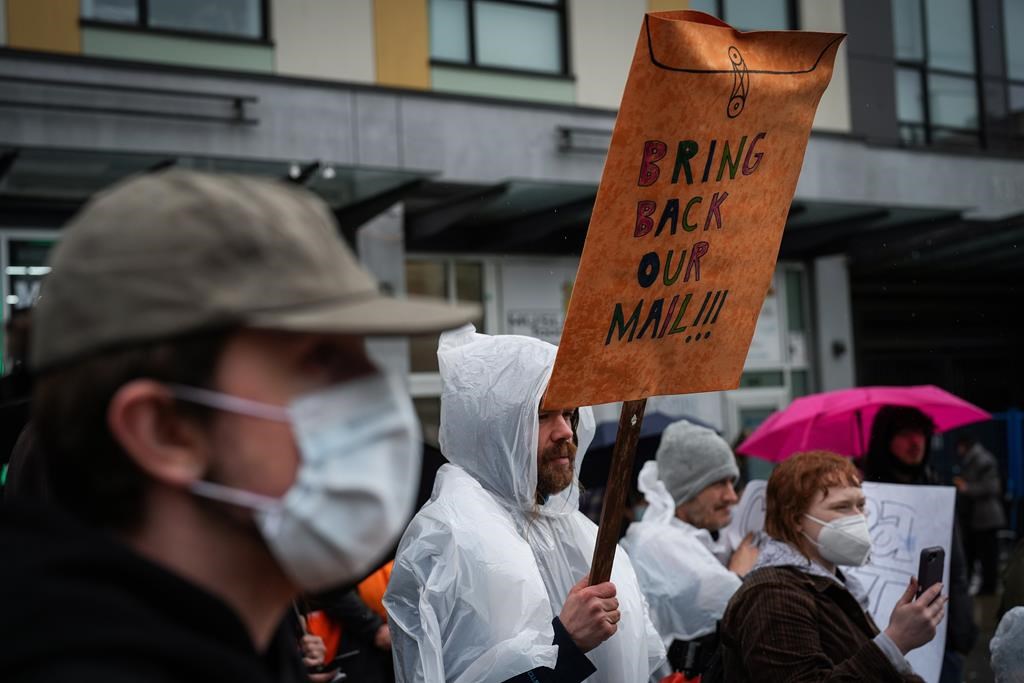 Protesters gather to rally against Canada Post's mail delivery suspension in Vancouver's Downtown Eastside