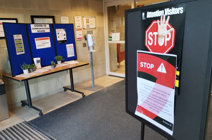 Warning signs and information about COVID-19 along with a hand sanitizing station is shown inside the doors of a Long-term care home in Oshawa, Ont., on Sunday, April 5, 2020.