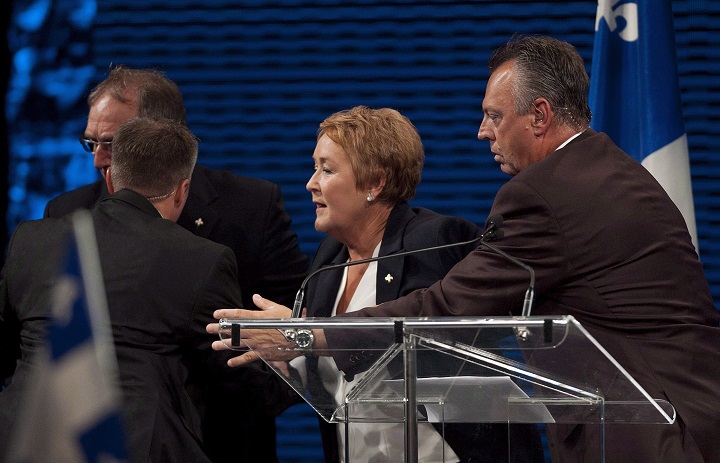 Parti Québecois Leader Pauline Marois is removed from the stage by SQ officers as she speaks to supporters in Montreal, Tuesday, September 4, 2012 following her election win. As the fifth anniversary of Quebec's election shooting approaches, Marois says she has forgiven the man who murdered a lighting technician that night and who was also intent on killing her. THE CANADIAN PRESS/Graham Hughes.