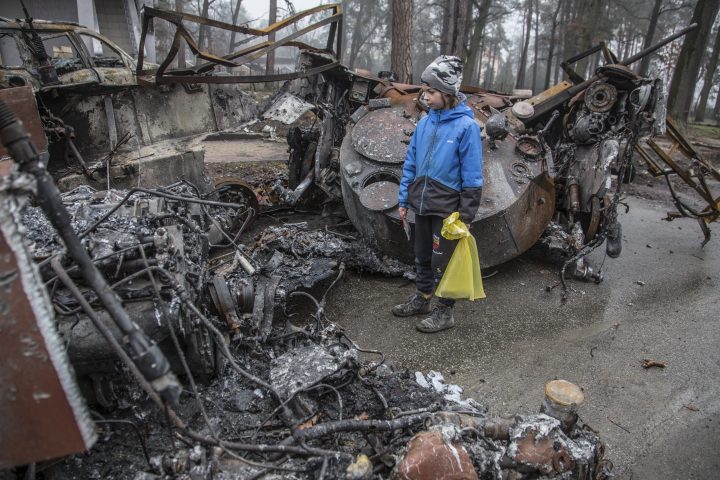 A boy looks at a destroyed Russian tank after recent battles in Bucha, close to Kyiv, Ukraine, on April 1.