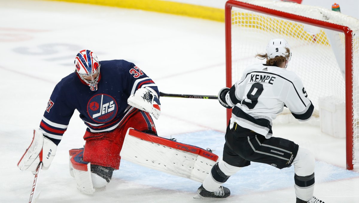 Los Angeles Kings' Adrian Kempe (9) scores on Winnipeg Jets goaltender Connor Hellebuyck (37) during first period NHL action in Winnipeg, Saturday, April 2, 2022. 
