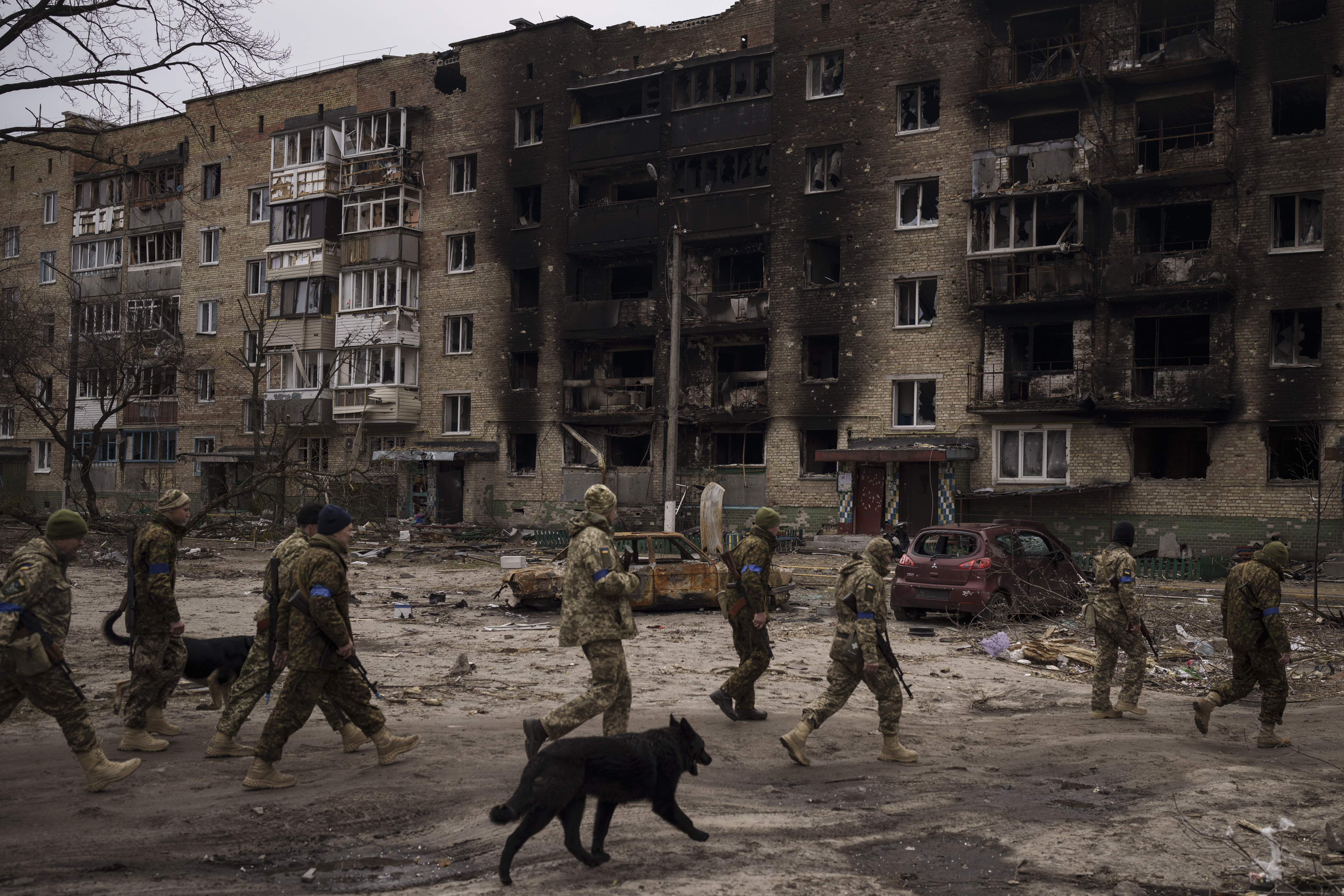 Ukrainian soldiers walk next to heavily damaged residential buildings in Irpin, on the outskirts of Kyiv, Ukraine.