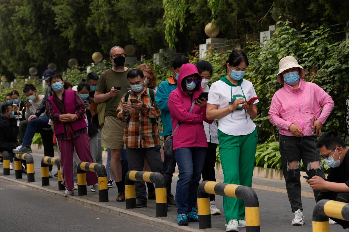 Residents wearing masks line up for mass COVID testing in Chaoyang District on Monday, April 25, 2022, in Beijing.
