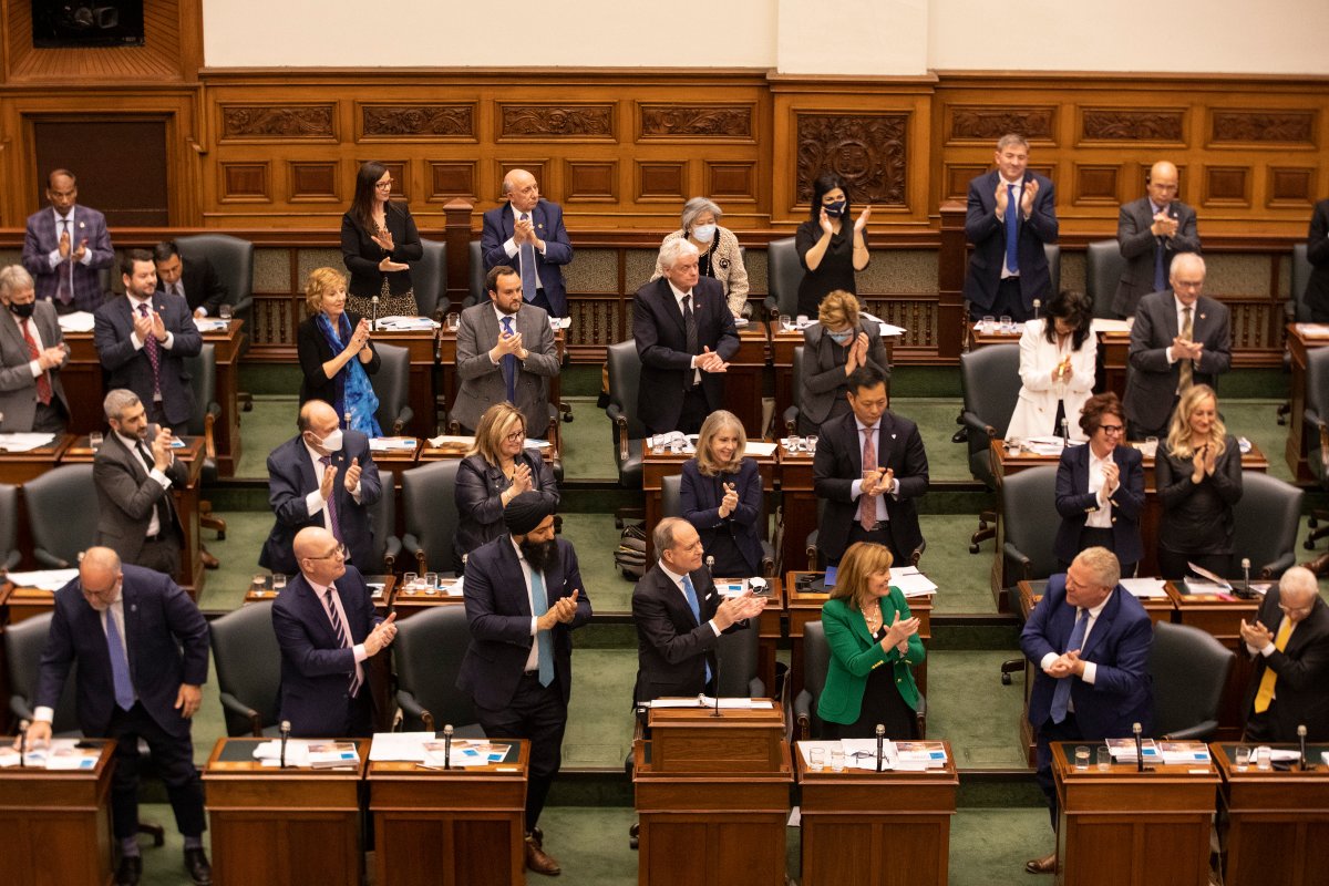 Peter Bethlenfalvy, Ontario's Minister of Finance (centre) and Premier Doug Ford (second right) exchange applause after the provincial government delivers it's 2022 budget at the Queens Park Legislature, in Toronto, on Thursday, April 28, 2022. THE CANADIAN PRESS/Chris Young.
