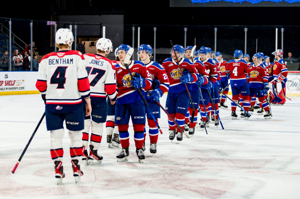 The Edmonton Oil Kings and the Lethbridge Hurricanes shake hands on the ice after a hockey game.