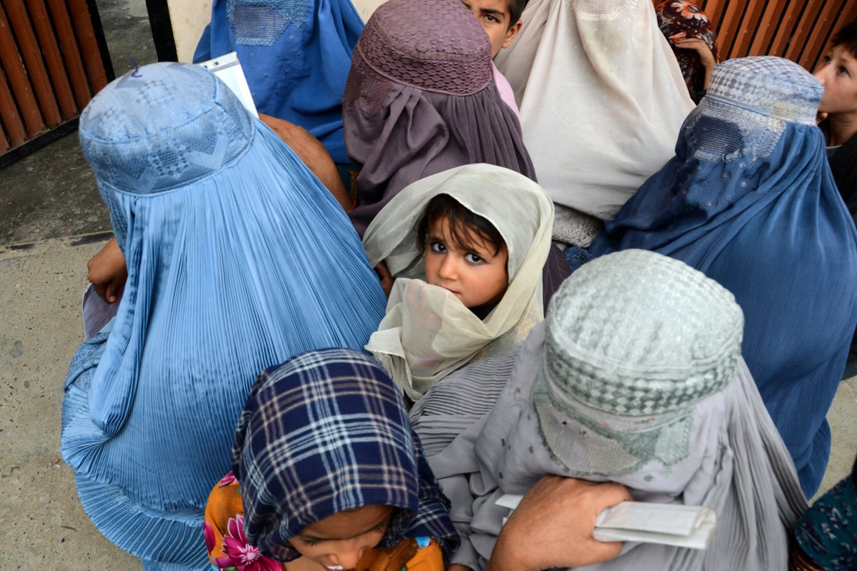 A young girl and other female refugees in Kandahar, Afghanistan wait for food at a United Nations facility.