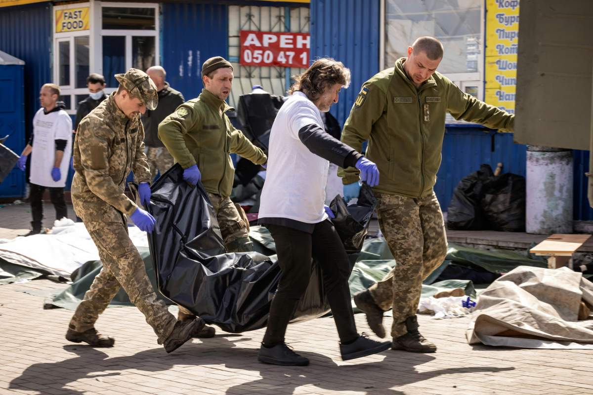 Ukrainian soldiers load bodies on a military truck after a rocket attack killed at least 35 people on April 8, 2022 at a train station in Kramatorsk, eastern Ukraine, that was being used for civilian evacuations.