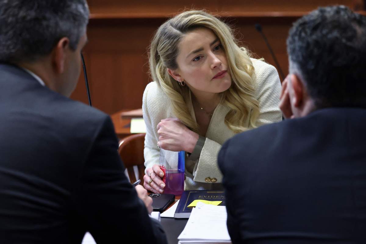 Actress Amber Heard talks to her attorneys during the defamation trial against her at the Fairfax County Circuit Courthouse in Fairfax, Virginia, April 20, 2022.