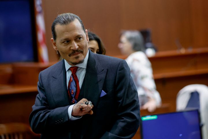 Actor Johnny Depp gestures as he stands in the courtroom during a recess amid his defamation trial against his ex-wife Amber Heard, at the Fairfax County Circuit Courthouse in Fairfax, Va., on April 27, 2022.