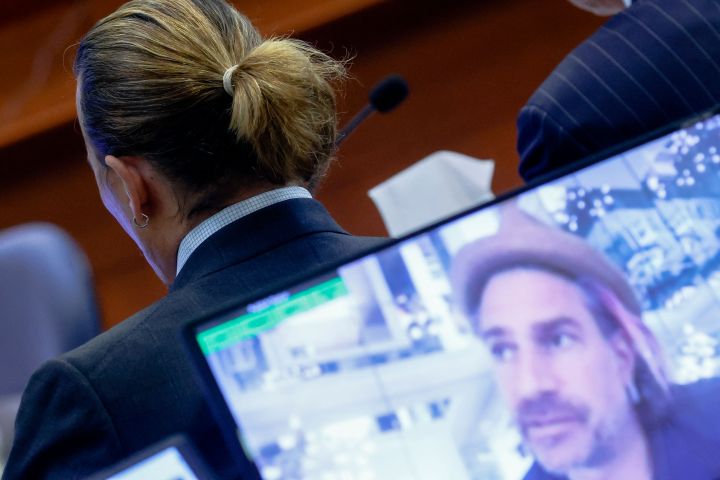 Actor Johnny Depp is seen as a pre-recorded deposition testimony of Christian Carino is played on screens during Depp's defamation trial against his ex-wife Amber Heard, at the Fairfax County Circuit Courthouse in Fairfax, Va., April 27, 2022.