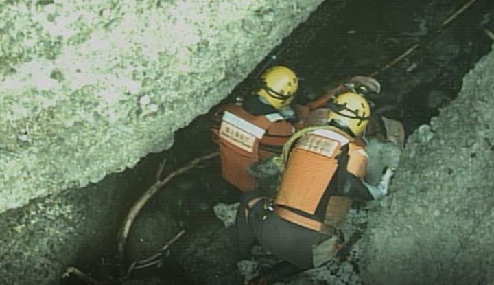 In this photo released by the 1st Regional Japan Coast Guard Headquarters, rescuers attend a person found on a rocky area near the tip of Shiretoko Peninsula in northern Japan of Hokkaido Sunday, April 24, 2022. 