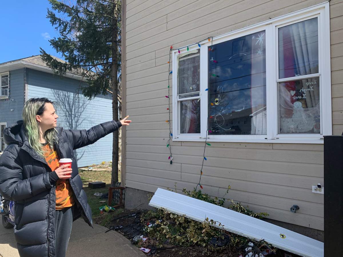 Jessica Oakley points to the bullet whole in her living room window.