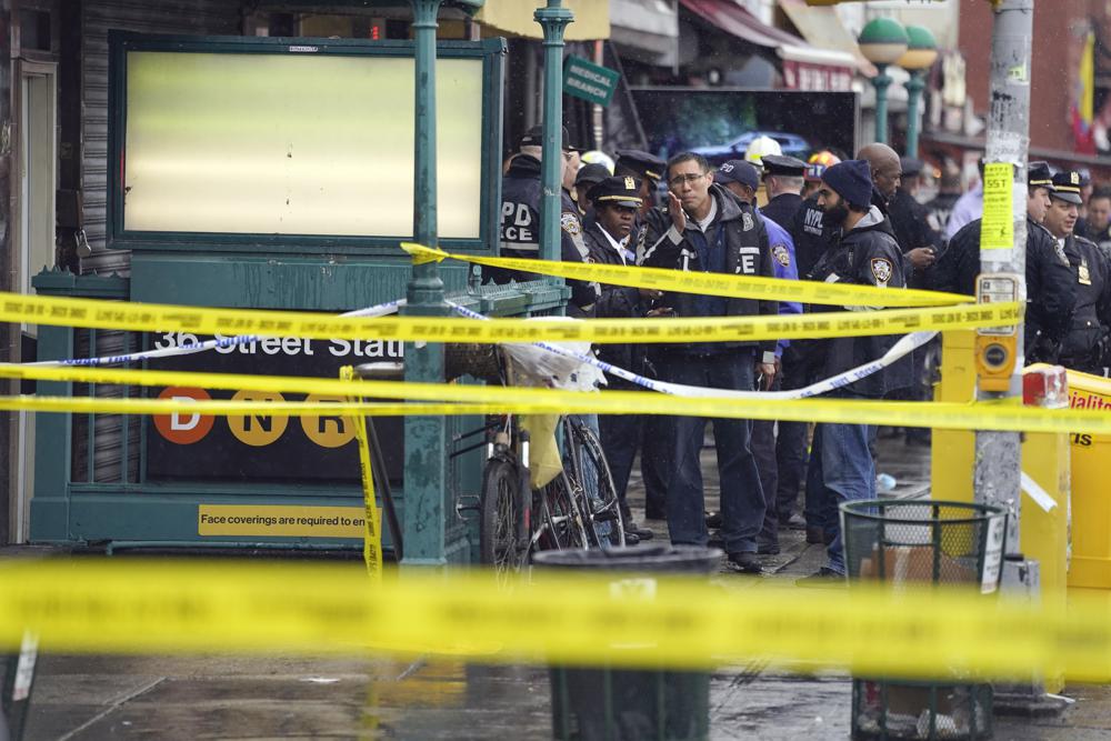 New York City Police Department personnel gather at the entrance to a subway stop in the Brooklyn borough of New York, Tuesday, April 12, 2022 (AP Photo/John Minchillo).