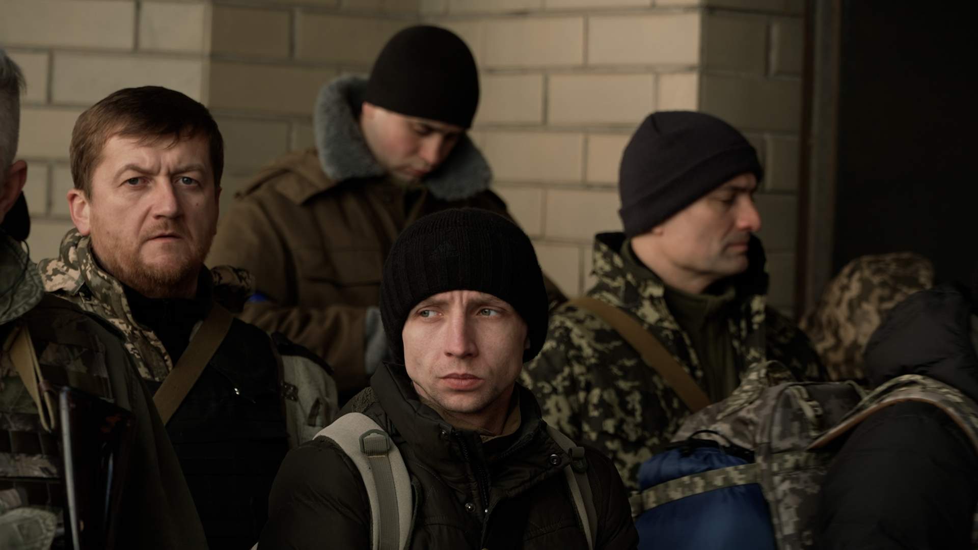 Members of Kyiv's territorial defense wait for a bus to arrive.