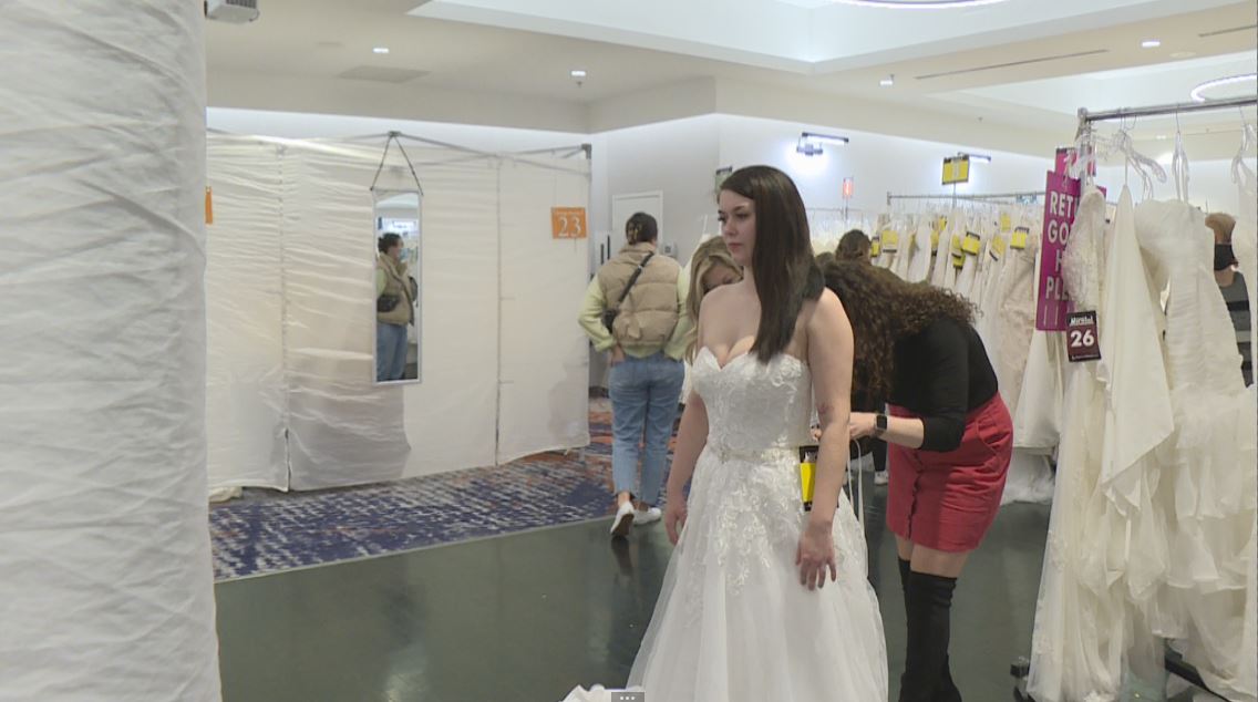 Ireland Desmarais tries on a wedding gown at Opportunity Bridal, a touring one-day pop-up shop that offers more than 800 dresses.