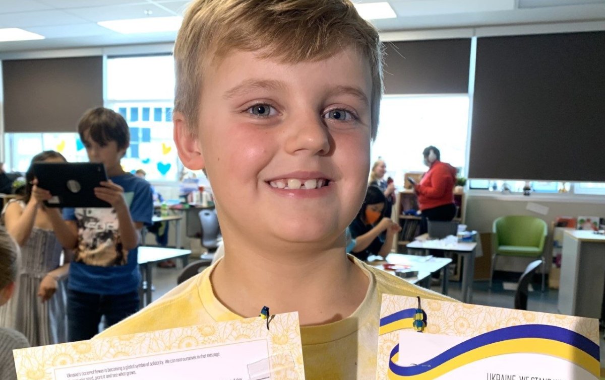 Drew Grabia, a Grade 3 student at David Thomas King School, poses with pins he made to fundraise for Ukraine refugees.