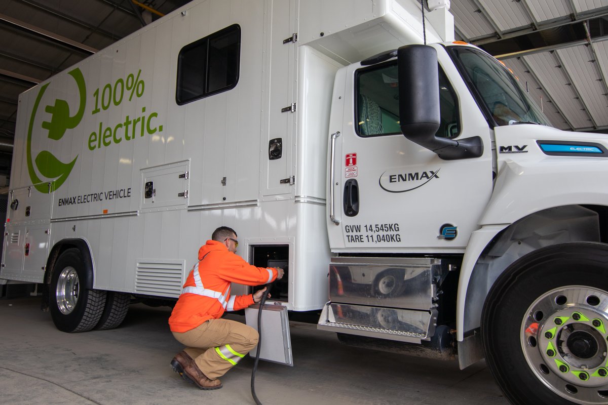 An Enmax worker plugs in one of the Calgary utility's two medium duty electric vehicles, on April 11, 2022.