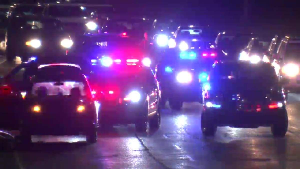 Calgary police attend to a vehicle along with EMS after the car was shot at in Crescent Heights on April 1, 2022.