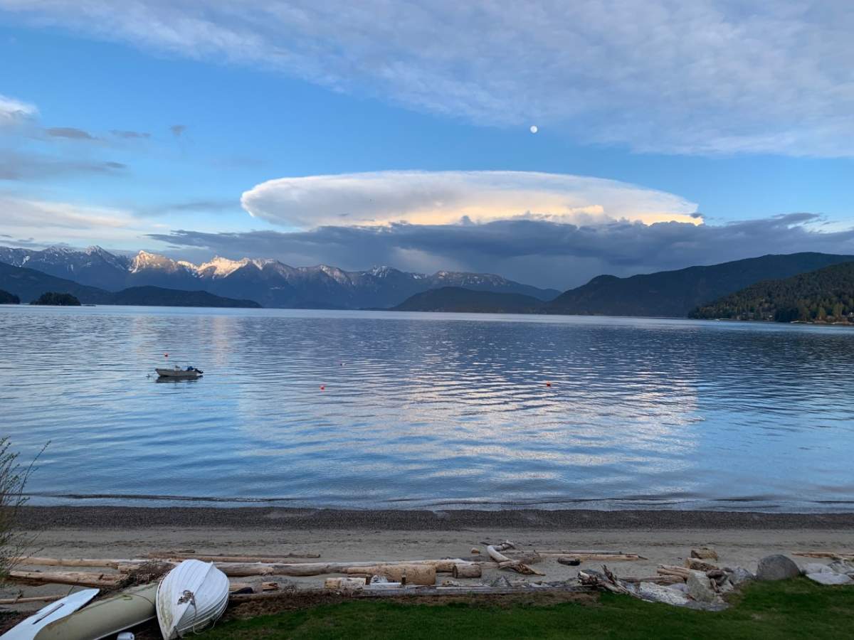 View of Cypress Mountain with the moon, mixed clouds and blue sky taken from Soames on the Sunshine Coast B.C.