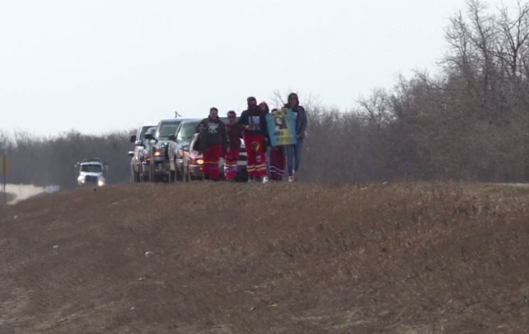 A group walks along Highway 28 to honour Billie Johnson.