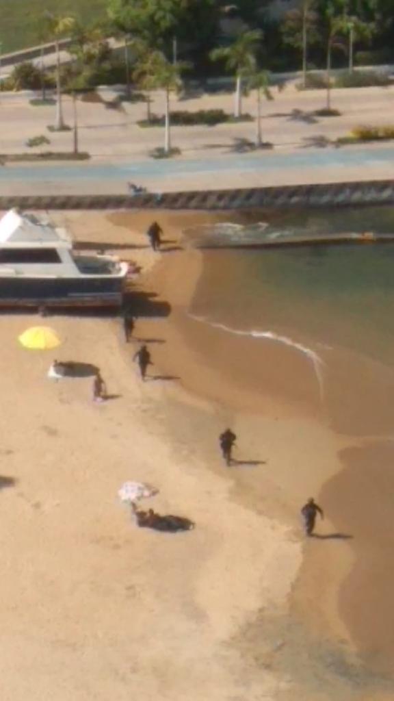 Mexican police chase after assailants following a shootout at a beachside restaurant that left at least three dead.
