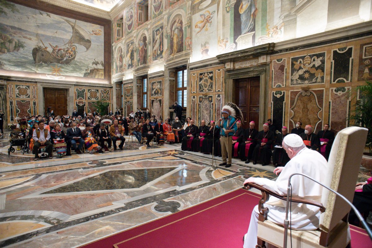 Pope Francis sits in a chair and looks out to an audience of Indigenous people gathered to hear his apology for the residential school system.