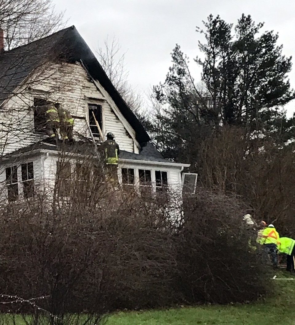 Firefighters are seen climbing the home in Smith’s Cove as they put out a fire.