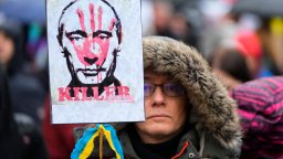 Russian President Vladimir Putin's face is stamped with 'killer' on a placard.