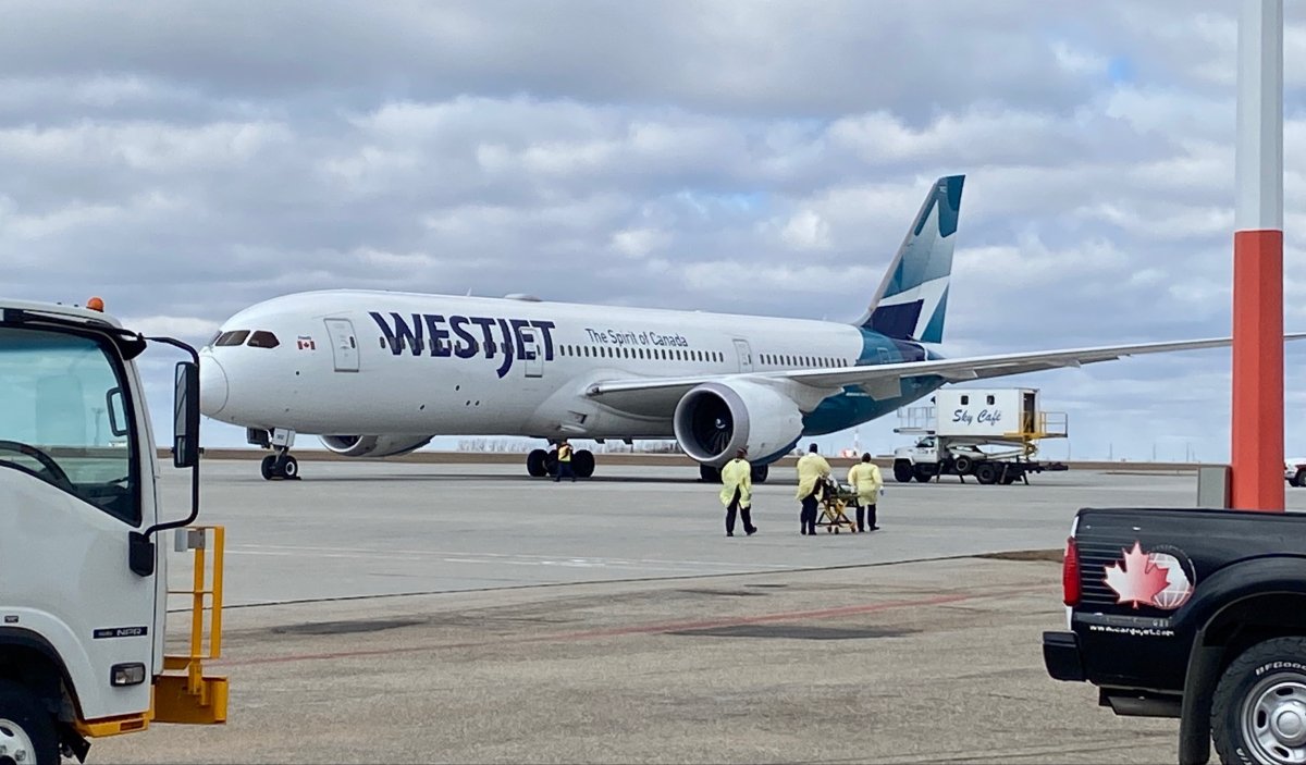 This image shows first responders pushing a stretcher towards the WestJet Boeing 787 plane that unexpectedly landed on Friday, April 1, 2022 in Regina.