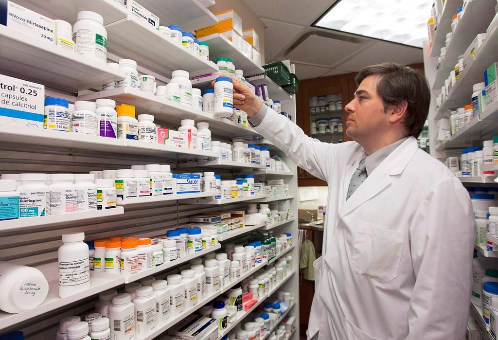 Pharmacist Denis Boissinot checks a bottle on a shelf at his pharmacy on March 8, 2012 in Quebec City.