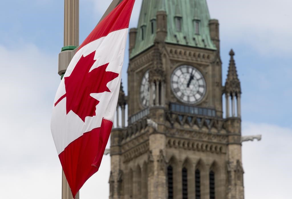 A Canadian flag hangs from a lamp post along the road in front of the Parliament buildings in Ottawa, Tuesday, June 30, 2020. 