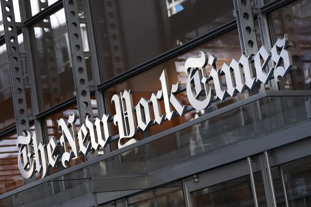 A sign for The New York Times hangs above the entrance to its building