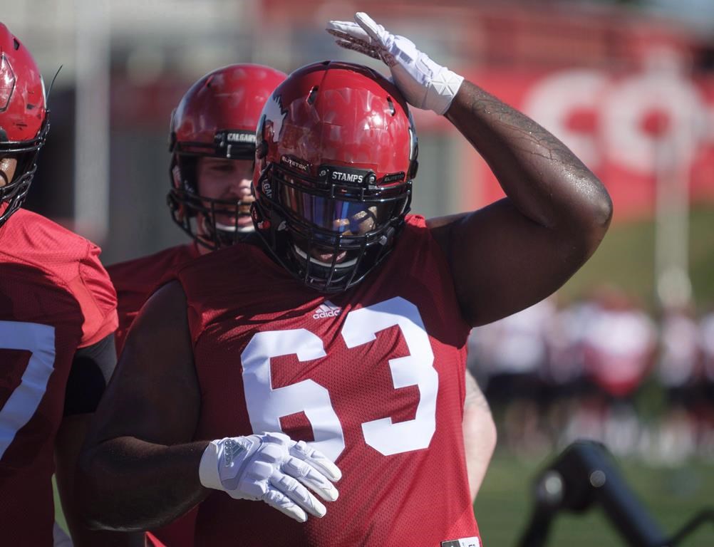 Calgary Stampeders' Derek Dennis adjusts his helmet on opening day of training camp in Calgary, Sunday, May 20, 2018. THE CANADIAN PRESS/Jeff McIntosh.