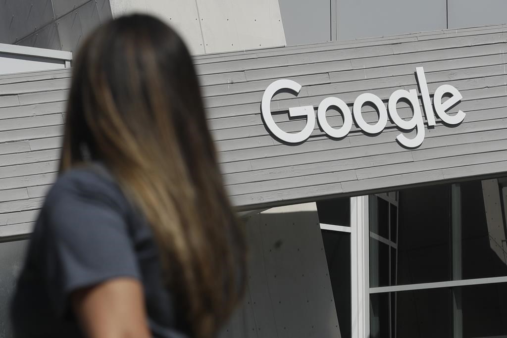 A woman walks below a Google sign on the campus in Mountain View, Calif., on Sept. 24, 2019.