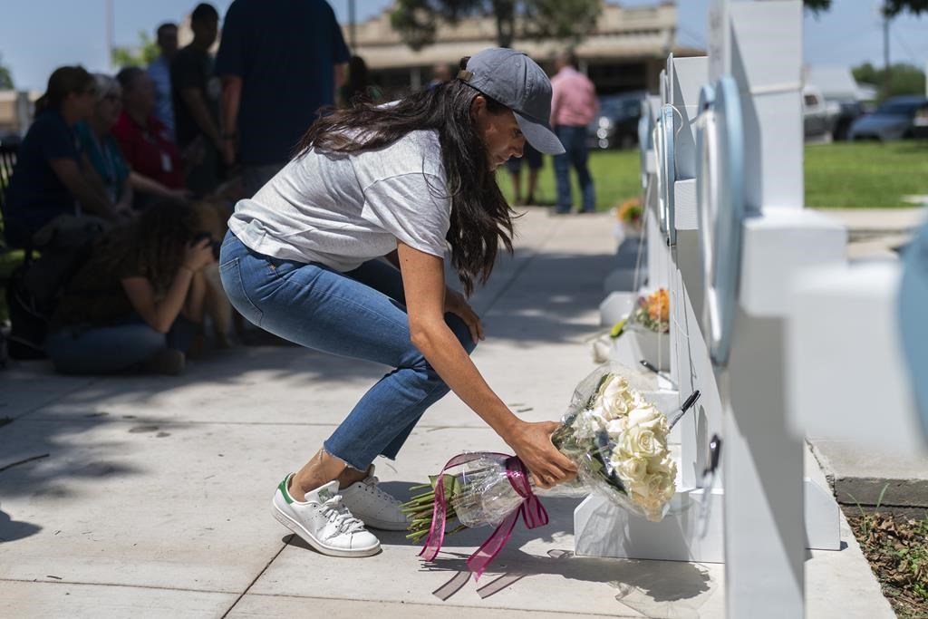 Meghan Markle, Duchess of Sussex, leaves flowers at a memorial site, Thursday, May 26, 2022, for the victims killed in this week’s elementary school shooting in Uvalde, Texas.
