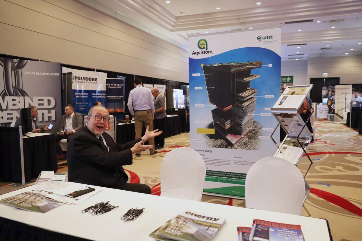 PTRC director of communications Norm Sacuta sitting at one of the booths at the williston basin petroleum conference in Regina
