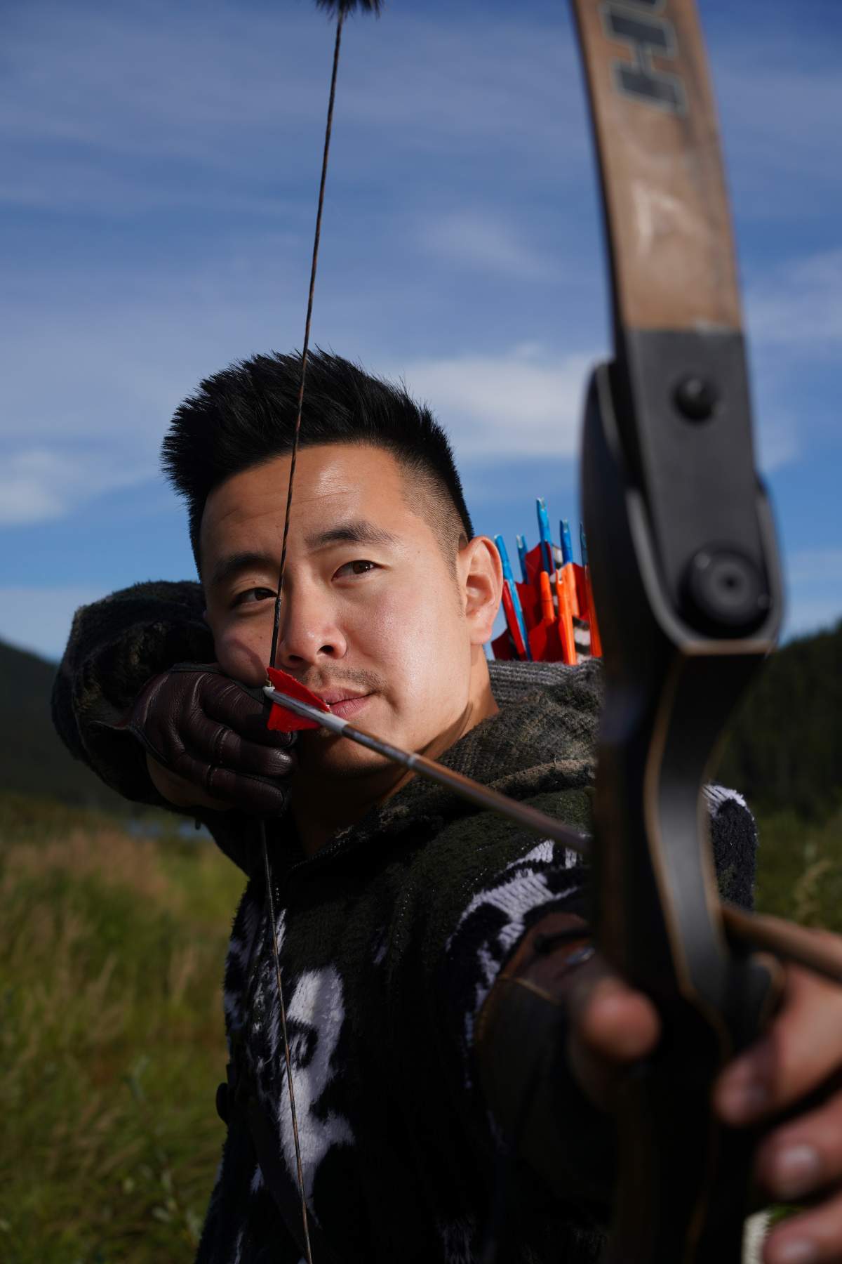 Teimojin Tan is competing for half a million dollars on Season 9 of 'Alone'. He is seen posing with his hunting bow.