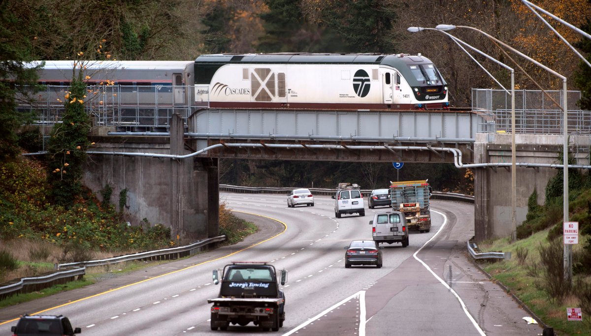 A northbound Amtrak Cascades train rolls across the Interstate 5 overpass in DuPont, Wash., on Thursday, Nov. 18, 2021.