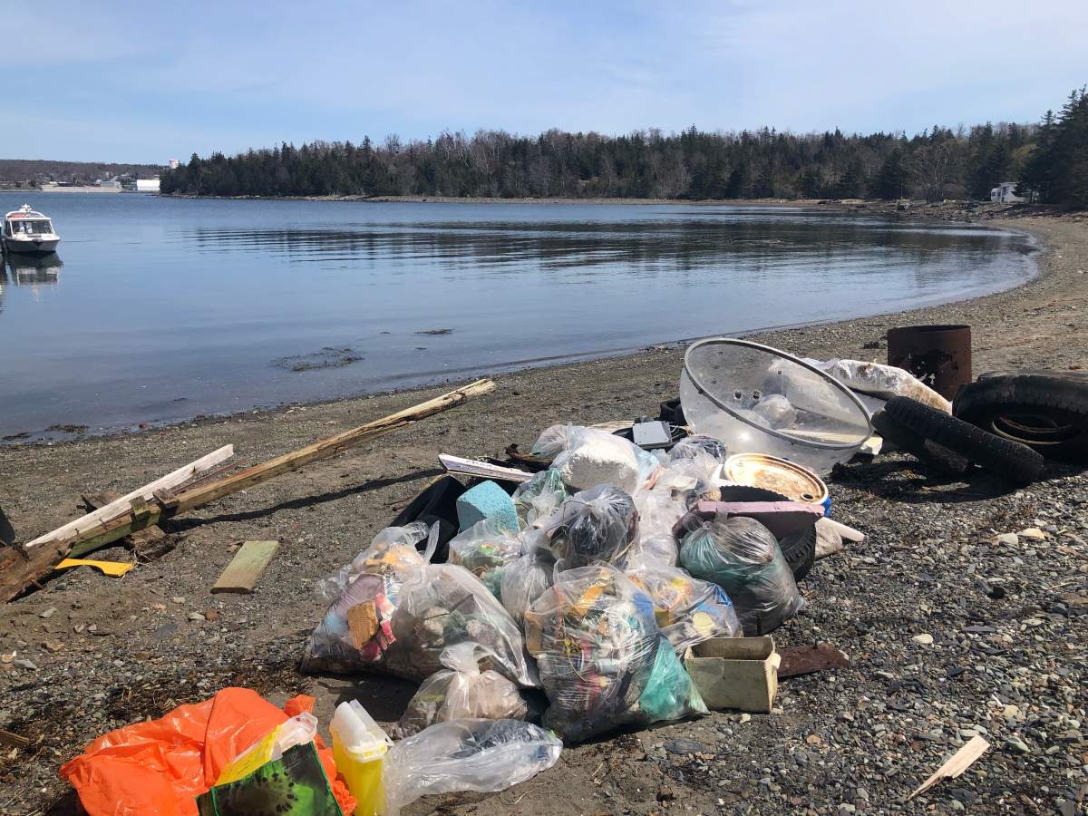 Garbage gathered by volunteers is piled up along a beach in Nova Scotia.