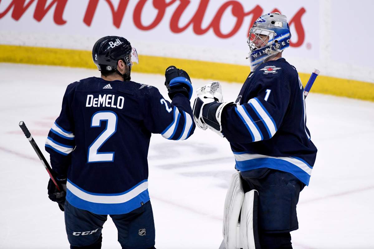 Winnipeg Jets' goaltender Eric Comrie (1) celebrates the win over the Seattle Kraken with Dylan DeMelo (2) in Winnipeg on May 1, 2022.