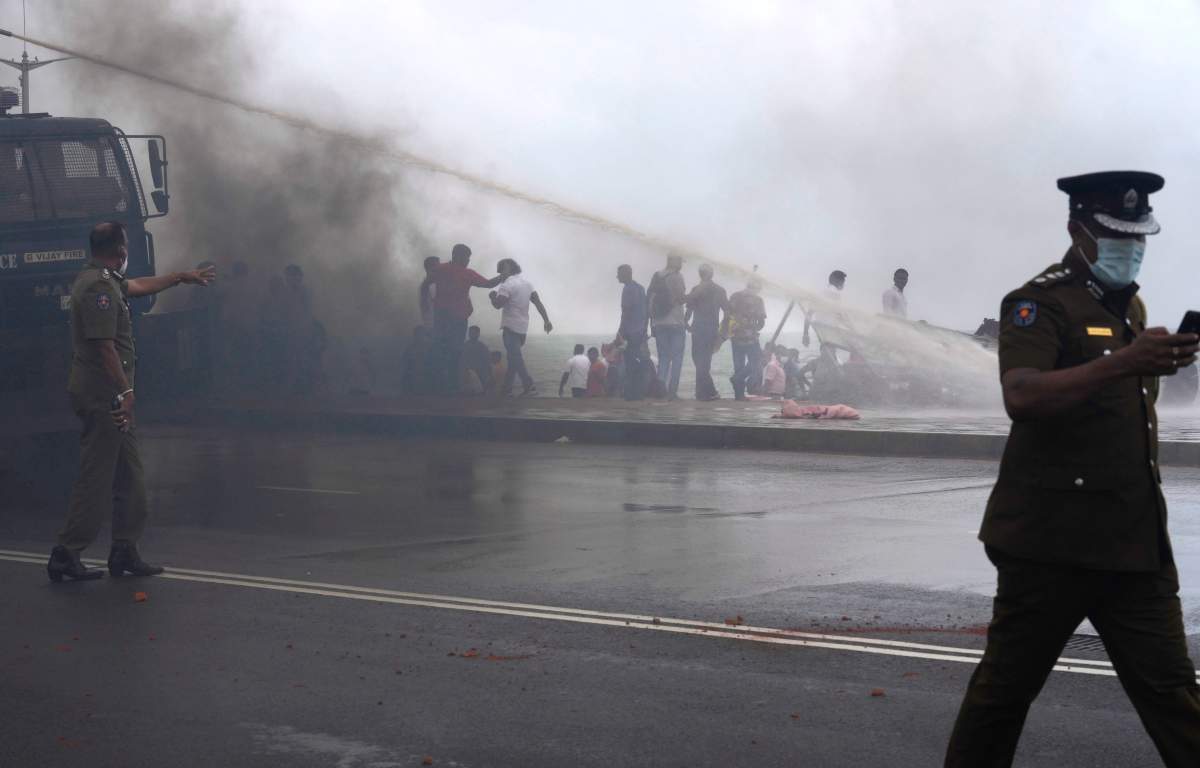 Sri Lanka’s pro government and anti government protestors clash as police fires water canons outside the president’s office in Colombo, Sri Lanka, Monday, May 9, 2022.