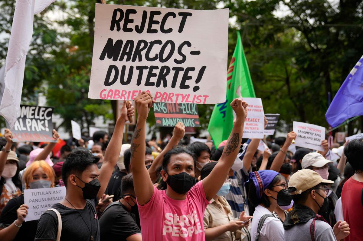 A protester holds a slogan during a rally in front of the office of the Commission on Elections as they question the results of the presidential elections in Manila, Philippines on Tuesday May 10, 2022.