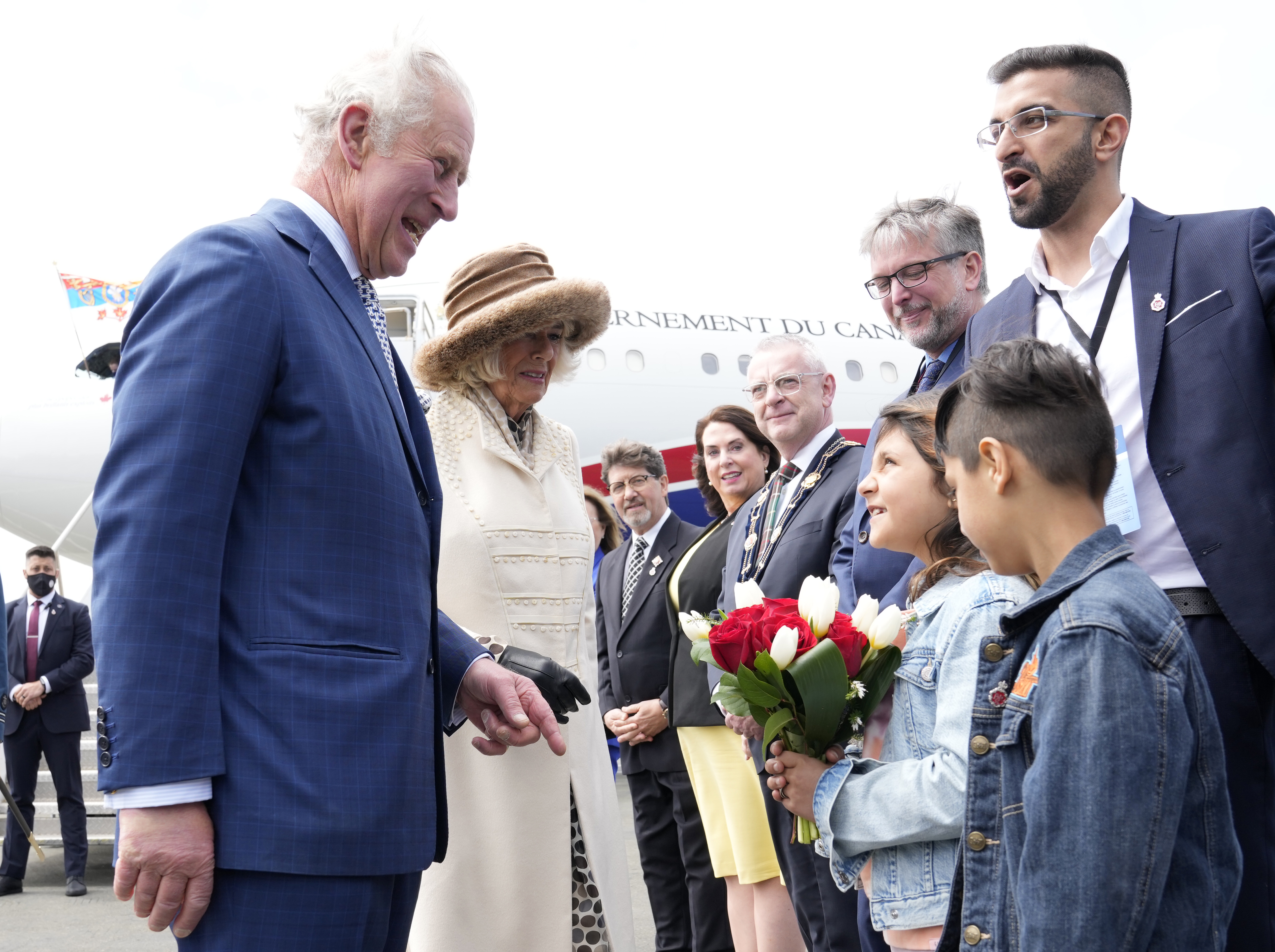 Prince Charles and Camilla receive flowers as they are greeted on the arrival in St. John's